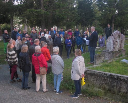 Gruppe mennesker samlet rundt det en gravstein